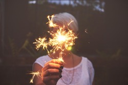 Blonde woman having fun with a sparkler.