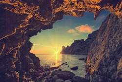 Vintage sea sunset from the mountain cave