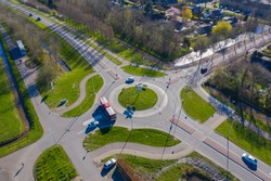 aerial drone view of a roundabout road way in The Netherlands, zuid holland / Utrecht. village of Wilnis with traffic and transportation. infrastructure from above road plus  bicycle lane