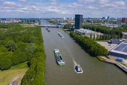 aerial drone footage of canal in the province of Utrecht with inland freight ships passing by. The Netherlands. inland vessel. in the back is the A12 highway with the prins clausbrug / galecopperbrug