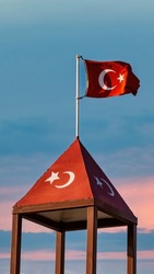 Turkish flag waving at blue sky. The flag of Turkey, officially the Turkish flag is a red flag featuring a white star and crescent.