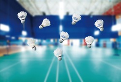 badminton - badminton courts with players competing; shuttlecocks in the foreground 