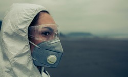 Closeup of woman with bacteriological protection suit on the beach