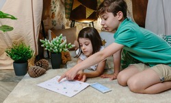 Children playing treasure hunting game in a diy tent at home. Home vacation concept
