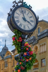 Beautiful floral decorations in Victory Square of Timisoara, Romania with old clock.