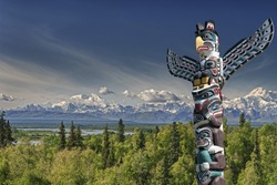 Isolated totem wood pole in mountain blue background