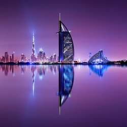 Detail of skyscraper reflection. Beautiful skyline scene in Dubai. Multiple highest buildings during night. The Palm island, United Arab Emirates.