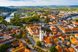 Aerial view of Old Town of Czech city of Pisek on Otava river overlooking white belfry of Church of Nativity of Blessed Virgin Mary on fall day