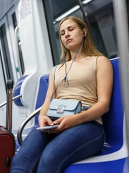 Portrait of young thoughtful woman traveler sitting in subway