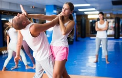 Young lady doing heel palm chin strike during group self-defence training.