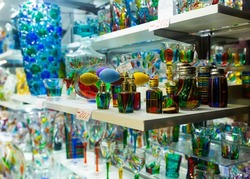 Original Murano art glass figures and glassware on display in Venetian souvenir shop ..