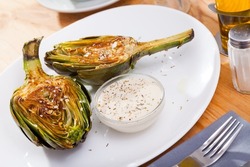Delicious fried artichoke halves with coarse salt on a white plate. High quality photo