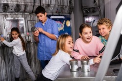 Smart tweenagers using computer trying to find solution of conundrum in lost room designed as bunker
