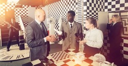 Five adults businesspeople solving different conundrums in quest room during corporate event.Toned image