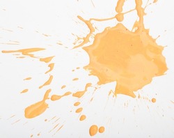 Spilled orange paint spots on paper, colorfull artistic image on white background