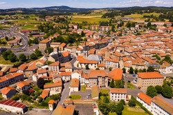 Aerial view of residential areas of French commune of Craponne-sur-Arzon with similar brownish roofs on summer day, Haute-Loire department.