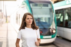 Portrait of young woman waiting tram on light rail station