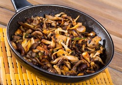 Close-up image of iron pan with freshly fried mushrooms