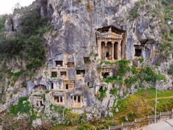 Modern view of remains of ancient Telmessos rock hewn tombs in stone cliff in city of Fethiye, Mugla Province, Turkey