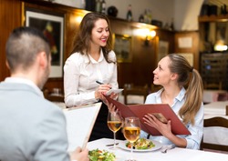 Hospitable waitress taking an order from a couple in a rural restaurant