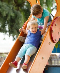 children on slide at playground area  in summer