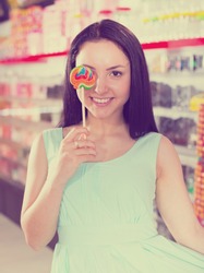 Pretty girl sucking   lollipop in the sweets store  