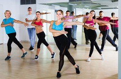 men and ladies dancing aerobics at lesson in the dance class