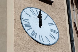 Clock dial on a bell tower at noon