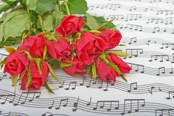 Bouquet of red roses on a background of music notes