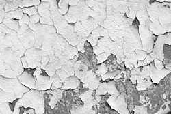 Grungy cracked white wall paint peeling off
