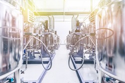 Photo of pipes and tanks. Chemistry and medicine production. Pharmaceutical factory. Interior of a high-tech plant, modern production. Yellow tone