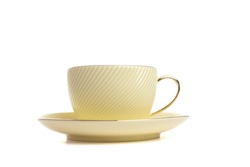 a tea pair with a lemon-colored saucer with a gold finish made of porcelain on a white isolated background