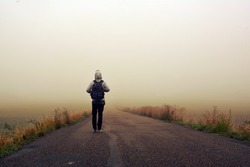 Man on the road in the foggy sunrise