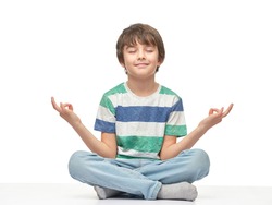 Caucasian children boy in a t-shirt doing yoga, isolated over the white background.