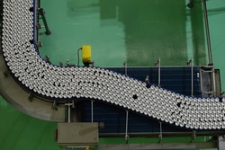 Conveyor line carrying thousands aluminum beverage cans at factory from top view