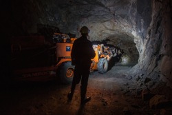 Man miner near undergroung Tamrock Minimatic Jumbo drilling rig machine in mine