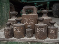 Old, metal weights of different size for a scale
