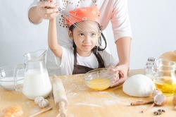 Close up shot of Asian little girl making bakery with mom with happiness , Select focus on face