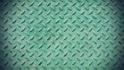 Texture of old metal diamond plate covered with green paint