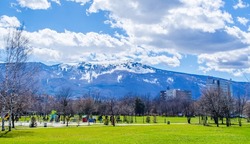 young bulgarians are walking through park in student city in sofia with vitosha mountain on background.