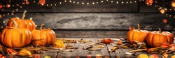Mini Thanksgiving Pumpkins And Leaves On Rustic Wooden Table With Lights And Bokeh On Wood Background - Thanksgiving / Harvest Concept