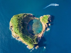 Azores aerial panoramic view. Top view of Islet of Vila Franca do Campo. Crater of an old underwater volcano. San Miguel island, Azores, Portugal. Heart carved by nature. Bird eye view.