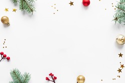 Christmas Background with fir branches, golden and red ornaments and stars, isolated on white background,  copy space. Christmas creative flat lay, concept with festive ornaments.