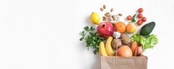 Healthy food background. Healthy vegan vegetarian food in paper bag vegetables and fruits on white, copy space, banner. Shopping food supermarket and clean vegan eating concept.