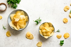 Homemade  potato chips in bowls.  Oven baked crispy potato chips on white background, top view, copy space.