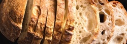 Fresh homebaked artisan sourdough bread. Texture of sliced loaf of bread close up, banner.