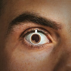 A mug of hot coffee is inserted into the man's pupil. Concept of caffeine effect, addiction