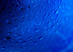 Water drops on radial blue background, soft focus, close up
