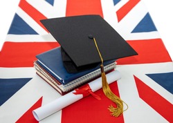 Great Britain education. Graduation diploma and academic graduate hat on the UK flag background. Great Britain education.