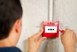 A back view of electrician installing fire alarm system